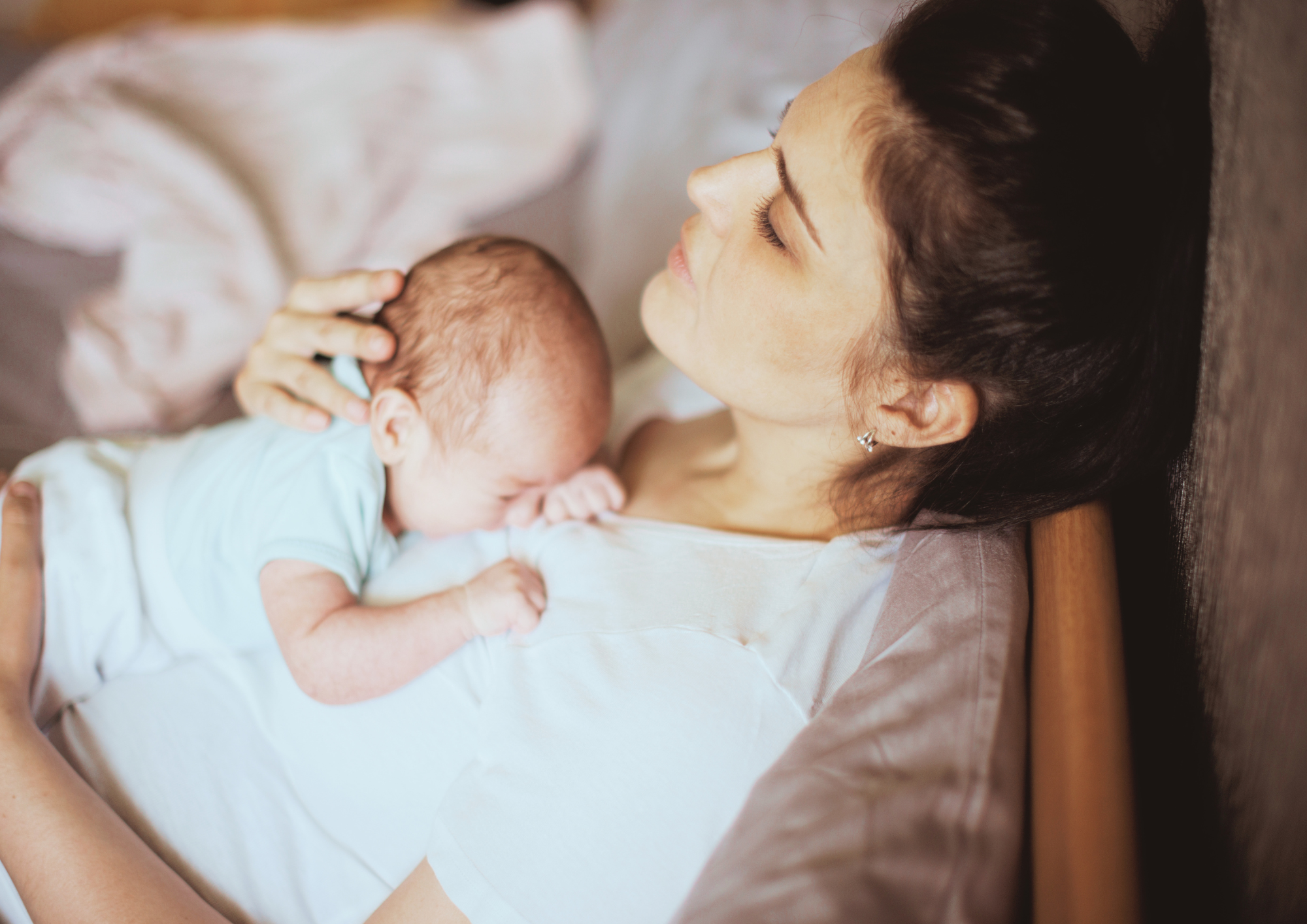 Une femme allongée avec son bébé dans les bras